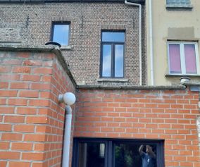 Levering en plaatsing zwarte pvc ramen achtergevel in Gent
